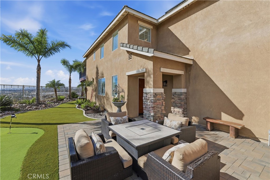 16123 Setting Sun Circle Riverside, CA 92503 - Photo 12 of 67 a view of a patio with couches table and chairs under an umbrella with a small yard