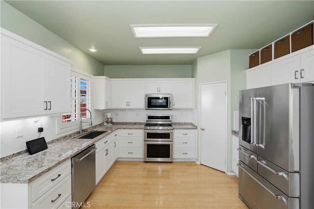16123 Setting Sun Circle Riverside, CA 92503 - Photo 3 of 67 a kitchen with stainless steel appliances granite countertop a refrigerator sink and stove