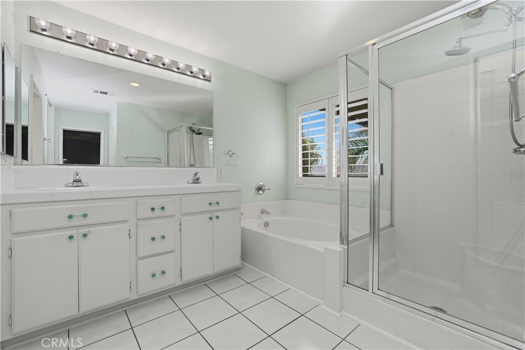16123 Setting Sun Circle Riverside, CA 92503 - Photo 34 of 67 a spacious bathroom with a double vanity sink a mirror a shower and a bathtub