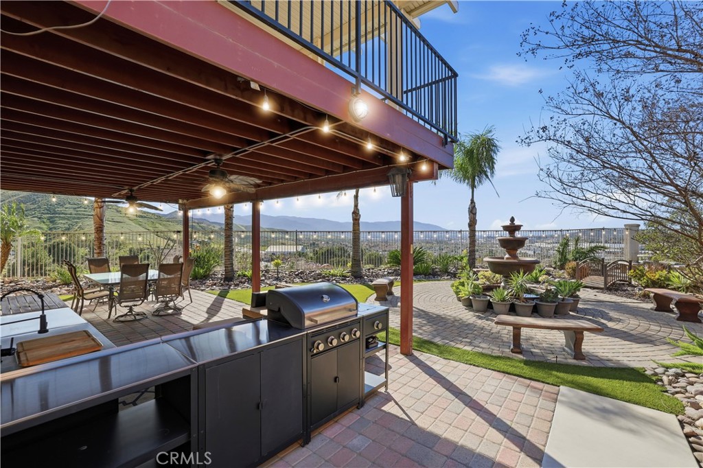 16123 Setting Sun Circle Riverside, CA 92503 - Photo 41 of 67 a roof deck with table and chairs under an umbrella with wooden floor