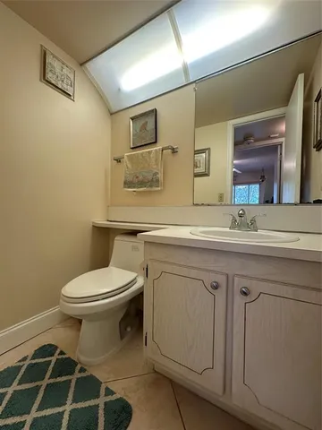a bathroom with a granite countertop toilet sink and mirror