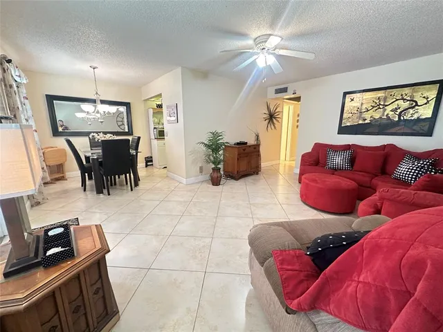 a living room with furniture a flat screen tv and a window