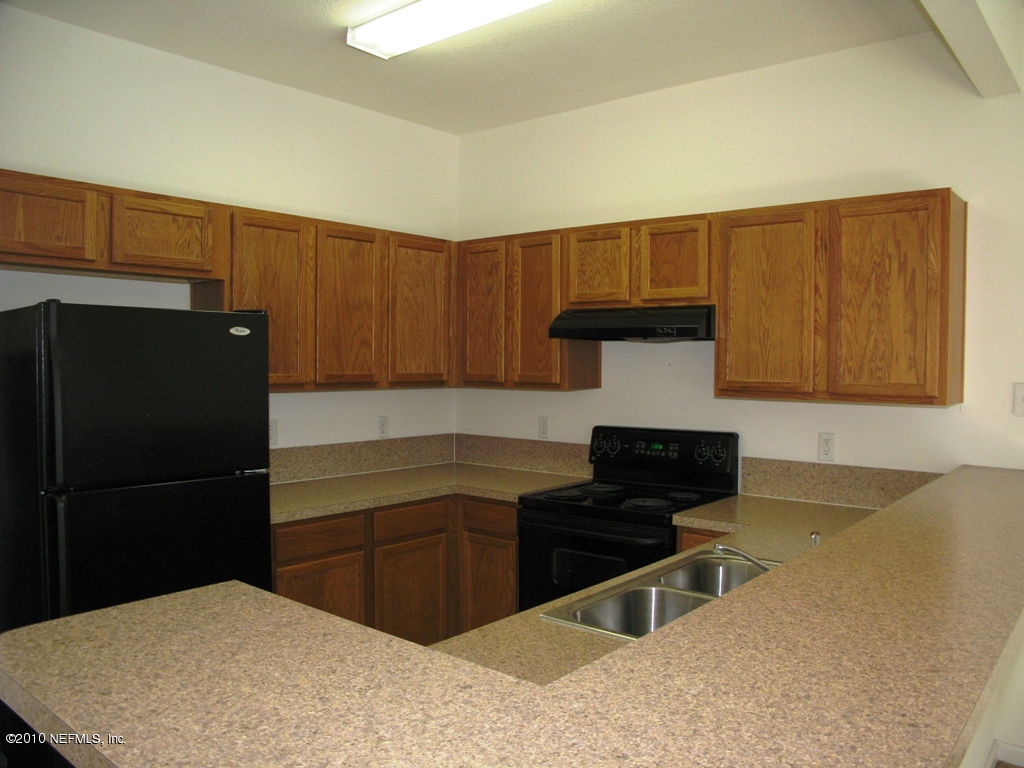 5880 Sandstone Way Jacksonville, FL 32258 - Photo 6 of 20 a kitchen with a refrigerator and a stove top oven
