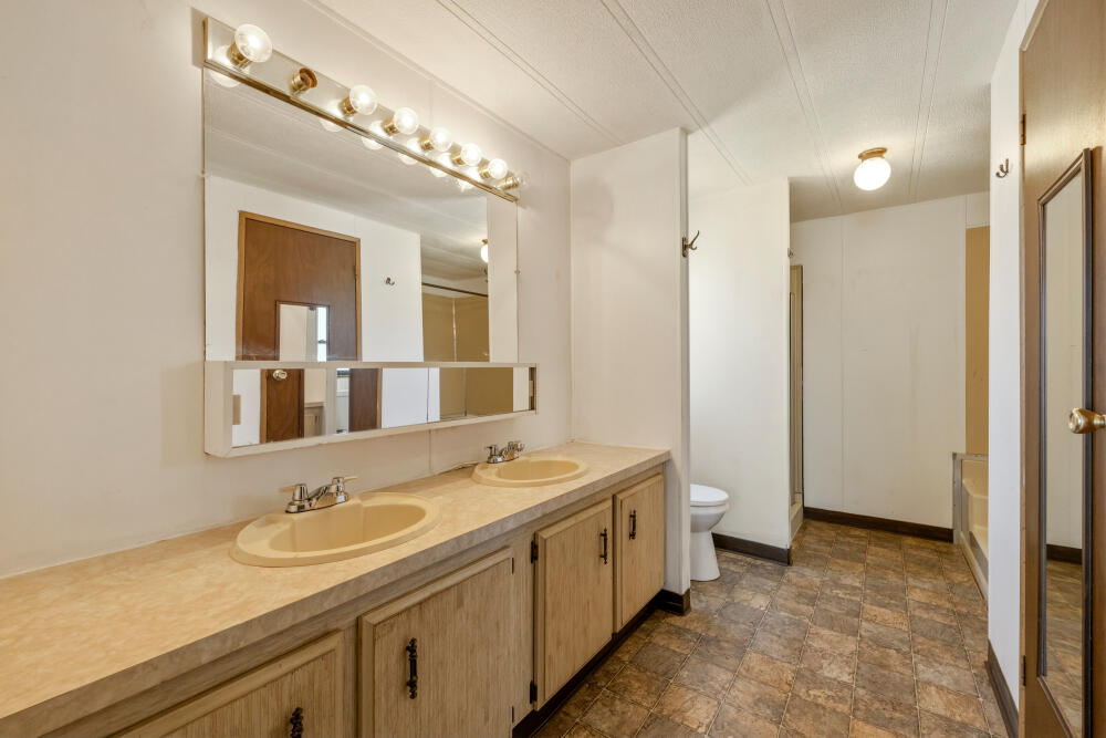 31410 Union Street Bonanza, OR 97623 - Photo 15 of 37 a bathroom with a granite countertop sink a large mirror and a shower