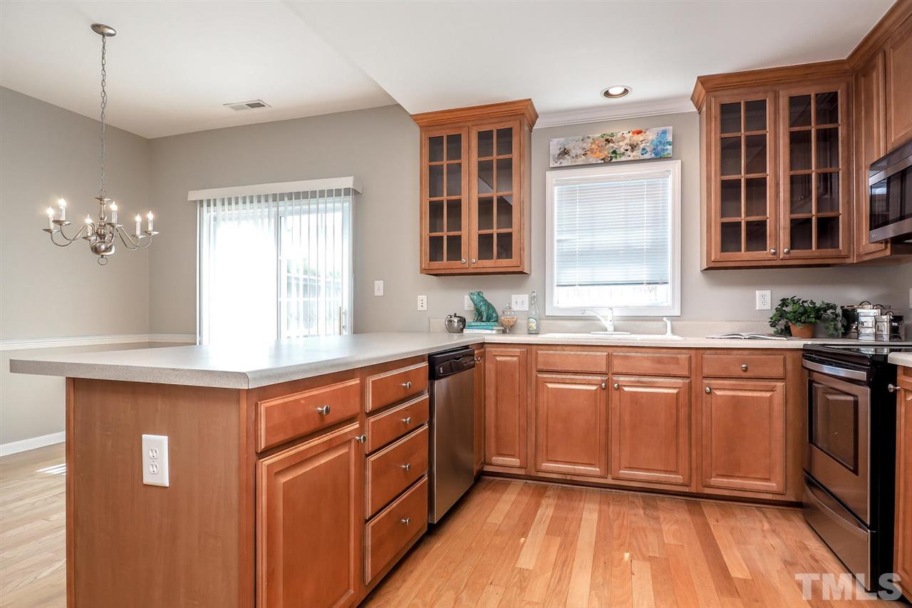 2041 Rivergate Road, Unit 105 Raleigh, NC 27614 - Photo 4 of 9 a kitchen with stainless steel appliances granite countertop wooden cabinets a sink and dishwasher with wooden floor