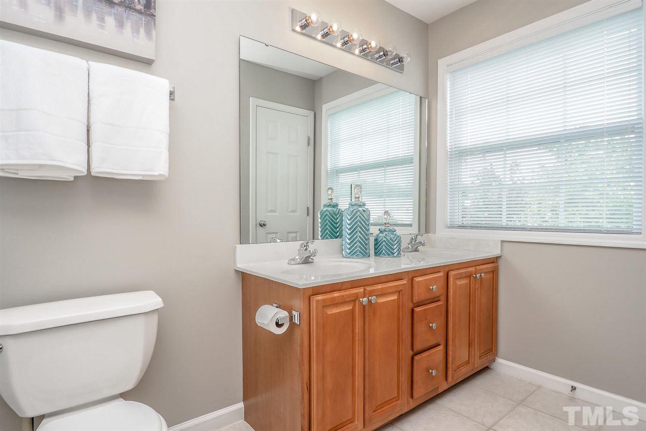 2041 Rivergate Road, Unit 105 Raleigh, NC 27614 - Photo 8 of 9 a bathroom with a granite countertop toilet a sink and a large mirror