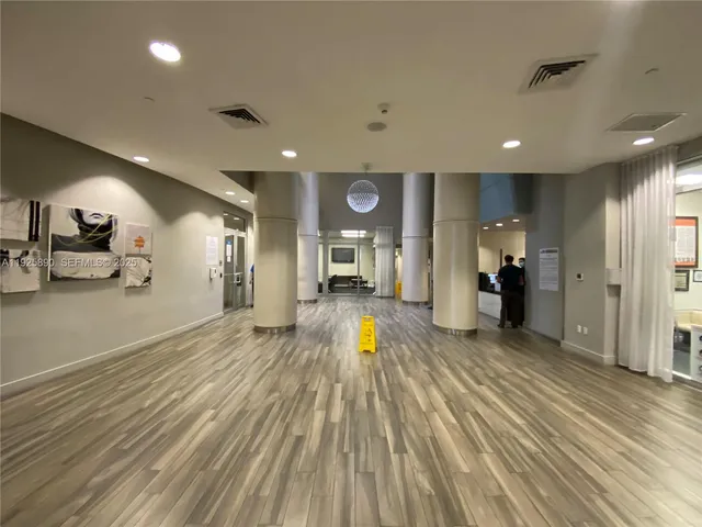 a view of a living room and a kitchen with wooden floor