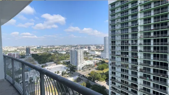 a view of a balcony with a floor to ceiling window and city view