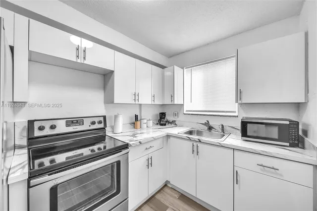 a kitchen with a sink stove and cabinets