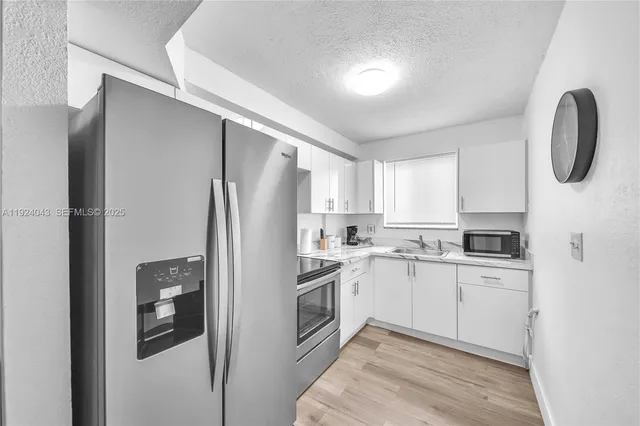 a kitchen with stainless steel appliances granite countertop a refrigerator and a stove top oven
