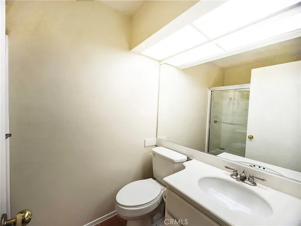 a bathroom with a sink a toilet and mirror