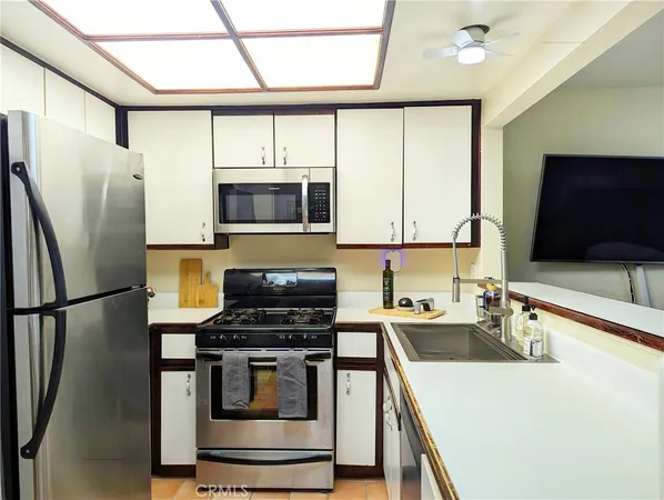a kitchen with stainless steel appliances a stove microwave and a sink