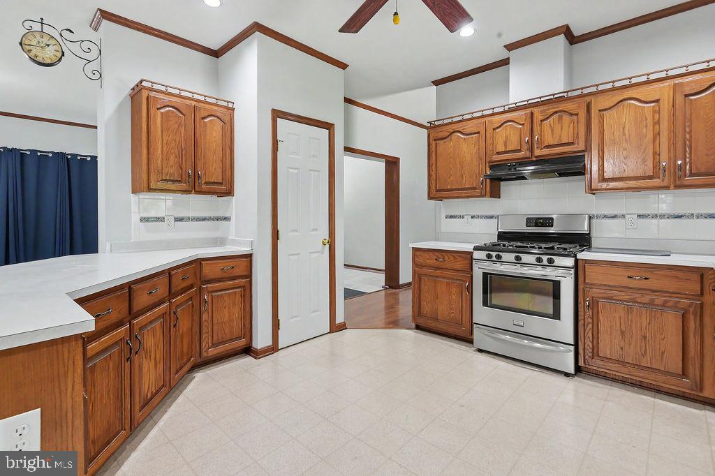 1204 A Old Coochs Bridge Road Newark, DE 19713 - Photo 5 of 31 a kitchen with stainless steel appliances granite countertop a stove top oven a refrigerator a sink and dishwasher with wooden cabinets
