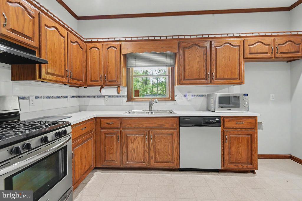 1204 A Old Coochs Bridge Road Newark, DE 19713 - Photo 7 of 31 a kitchen with stainless steel appliances granite countertop a stove a sink dishwasher and cabinets with wooden floor