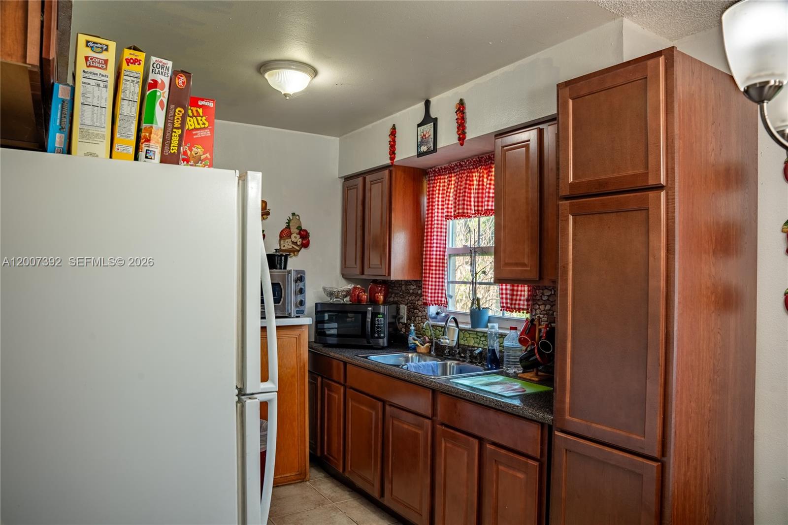 6924 Holly Creek Road Mount Dora, FL 32757 - Photo 17 of 25 a kitchen with stainless steel appliances a refrigerator and a window