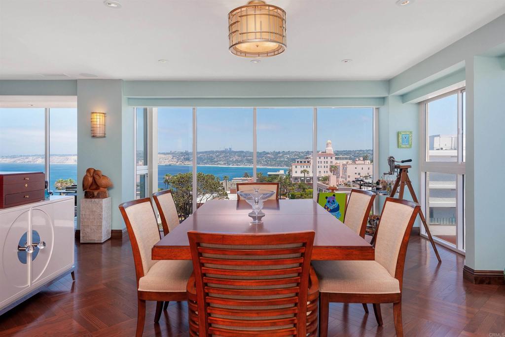 939 Coast Boulevard La Jolla, CA 92037 - Photo 11 of 36 a dining room with furniture a flat screen tv and a large window