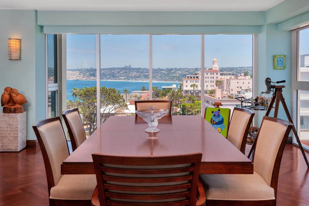 939 Coast Boulevard La Jolla, CA 92037 - Photo 12 of 36 a view of a dining room with furniture a chandelier and wooden floor