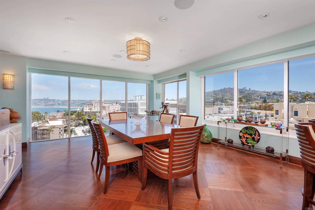 939 Coast Boulevard La Jolla, CA 92037 - Photo 14 of 36 a dining room with furniture a chandelier and wooden floor