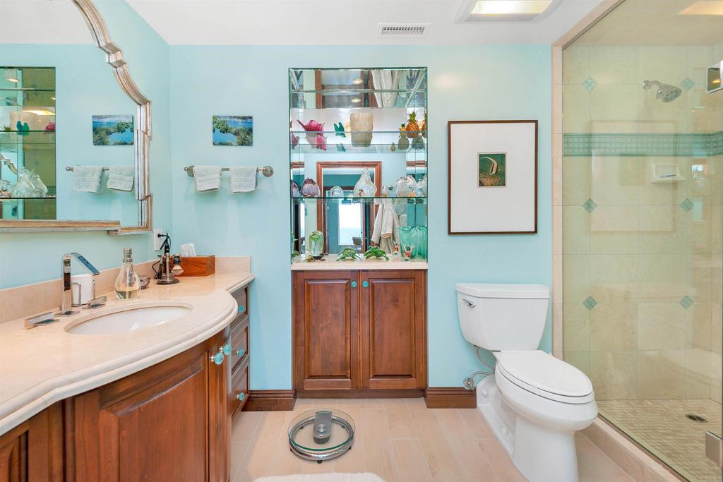 939 Coast Boulevard La Jolla, CA 92037 - Photo 22 of 36 a bathroom with a sink a toilet and shower curtain