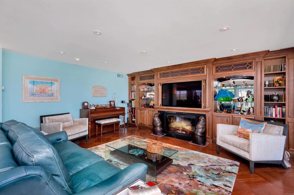 939 Coast Boulevard La Jolla, CA 92037 - Photo 4 of 36 a living room with furniture a flat screen tv and a fireplace