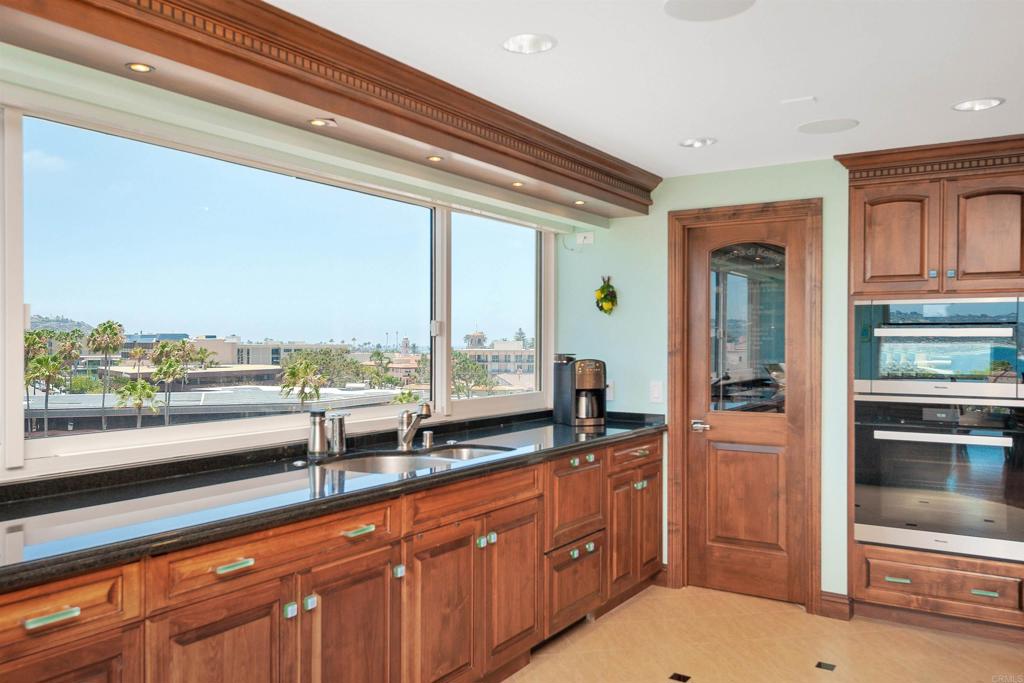 939 Coast Boulevard La Jolla, CA 92037 - Photo 5 of 36 a open kitchen with a large window and refrigerator