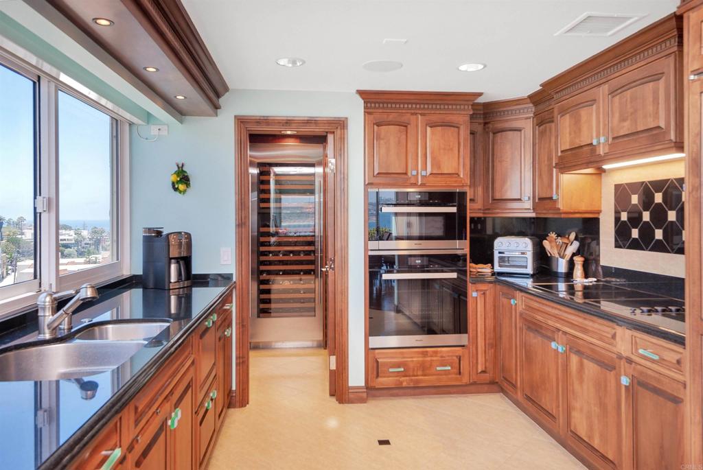 939 Coast Boulevard La Jolla, CA 92037 - Photo 8 of 36 a kitchen with stainless steel appliances granite countertop a refrigerator and a sink