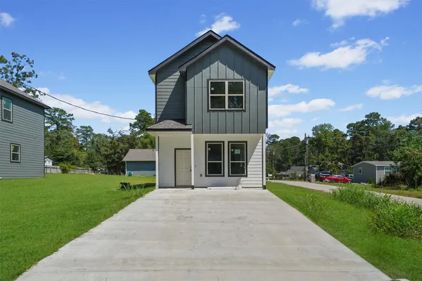 a front view of a house with a yard and potted plants