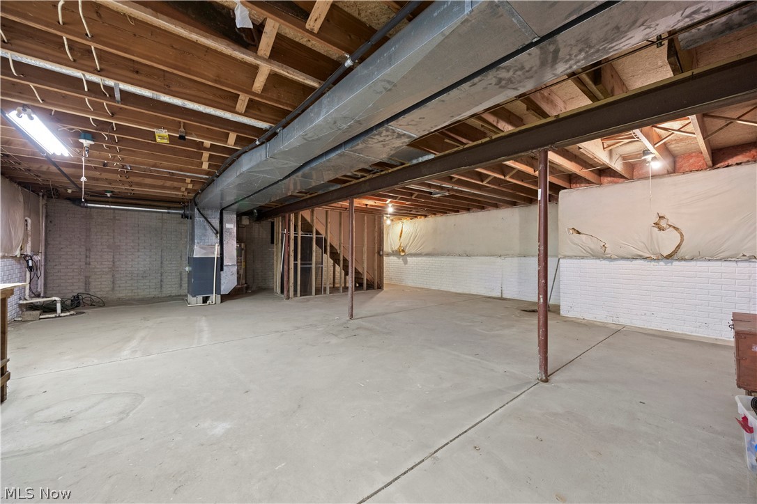 722 Jaycox Road Avon Lake, OH 44012 - Photo 41 of 48 Expansive unfinished basement featuring concrete flooring, exposed wood joists, a metal support beam, brick foundation walls, and framed sections for potential development
