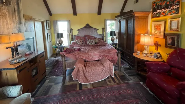 a bed room with furniture a flat screen tv and a fireplace