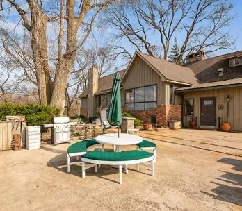 a view of a chair and table in backyard of the house