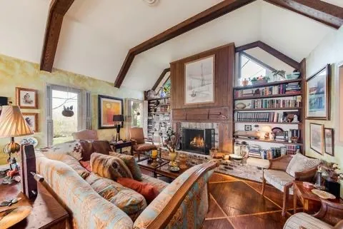 a living room with furniture a fireplace and a large window