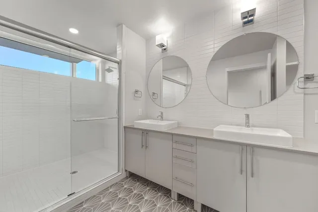 a bathroom with double vanity sinks and a mirror