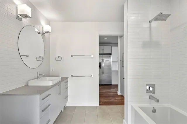 a bathroom with a double vanity sink mirror and shower
