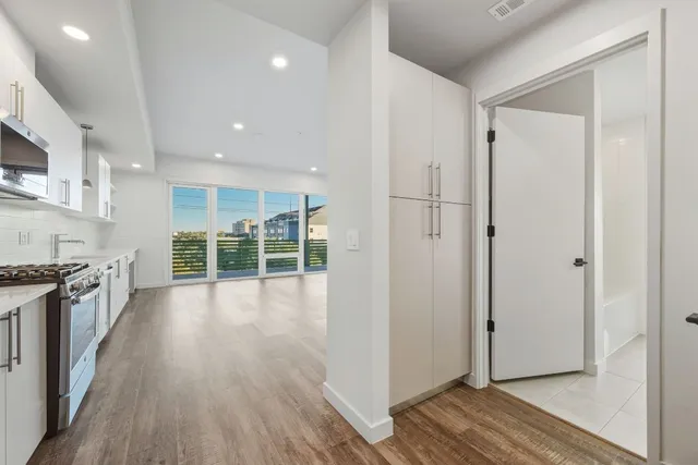 a view of a kitchen with wooden floor and electronic appliances