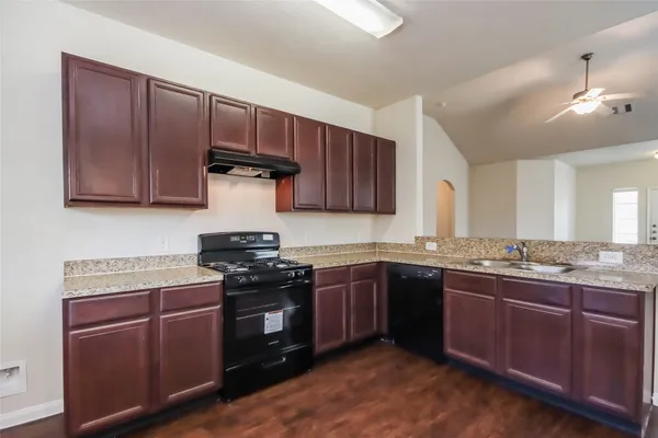 a kitchen with stainless steel appliances granite countertop wooden cabinets stove top oven and sink