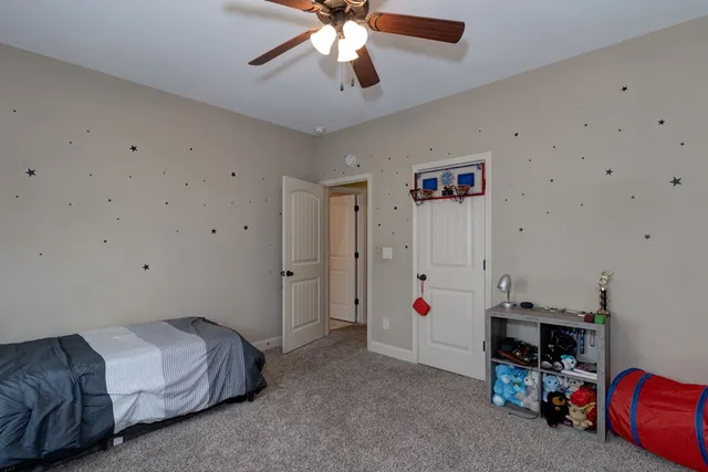 a spacious bedroom with a bed and a chandelier