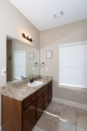 a bathroom with a granite countertop sink and a mirror