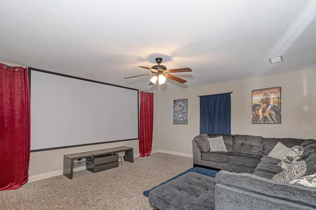 a living room with furniture and a ceiling fan