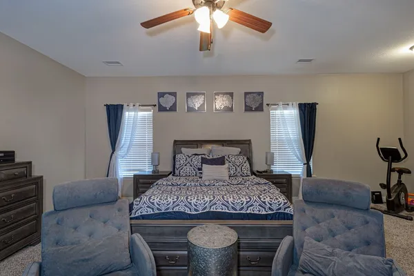 a bed sitting in a bedroom next to a window with pc on the table