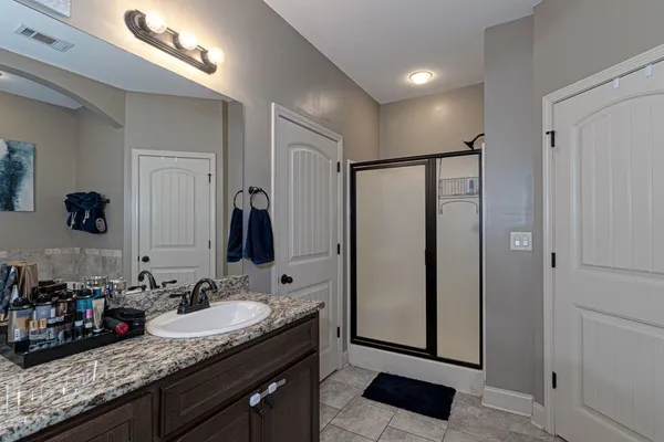 a bathroom with double vanity and a mirror
