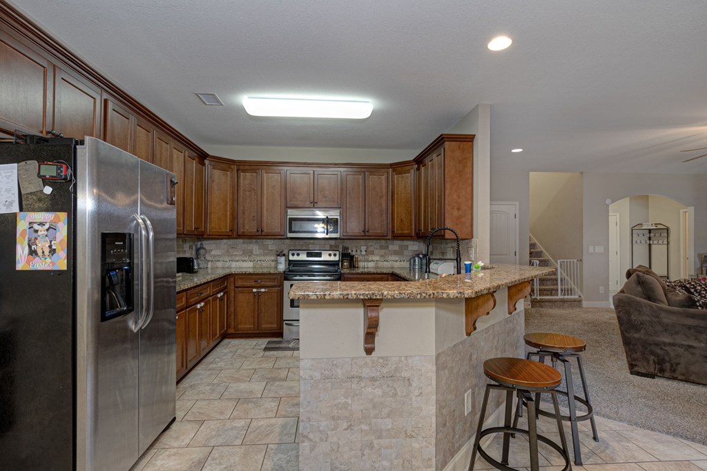 53 Winter Hawk Drive Fort Mitchell, AL 36856 - Photo 6 of 39 a kitchen with stainless steel appliances granite countertop a refrigerator a stove a sink a dining table and chairs