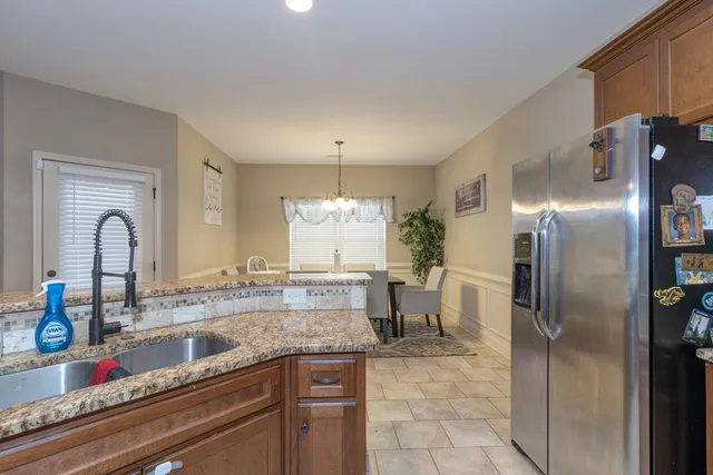 a kitchen with stainless steel appliances granite countertop a refrigerator and a sink