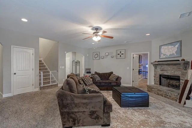 a living room with furniture a ceiling fan and a fireplace