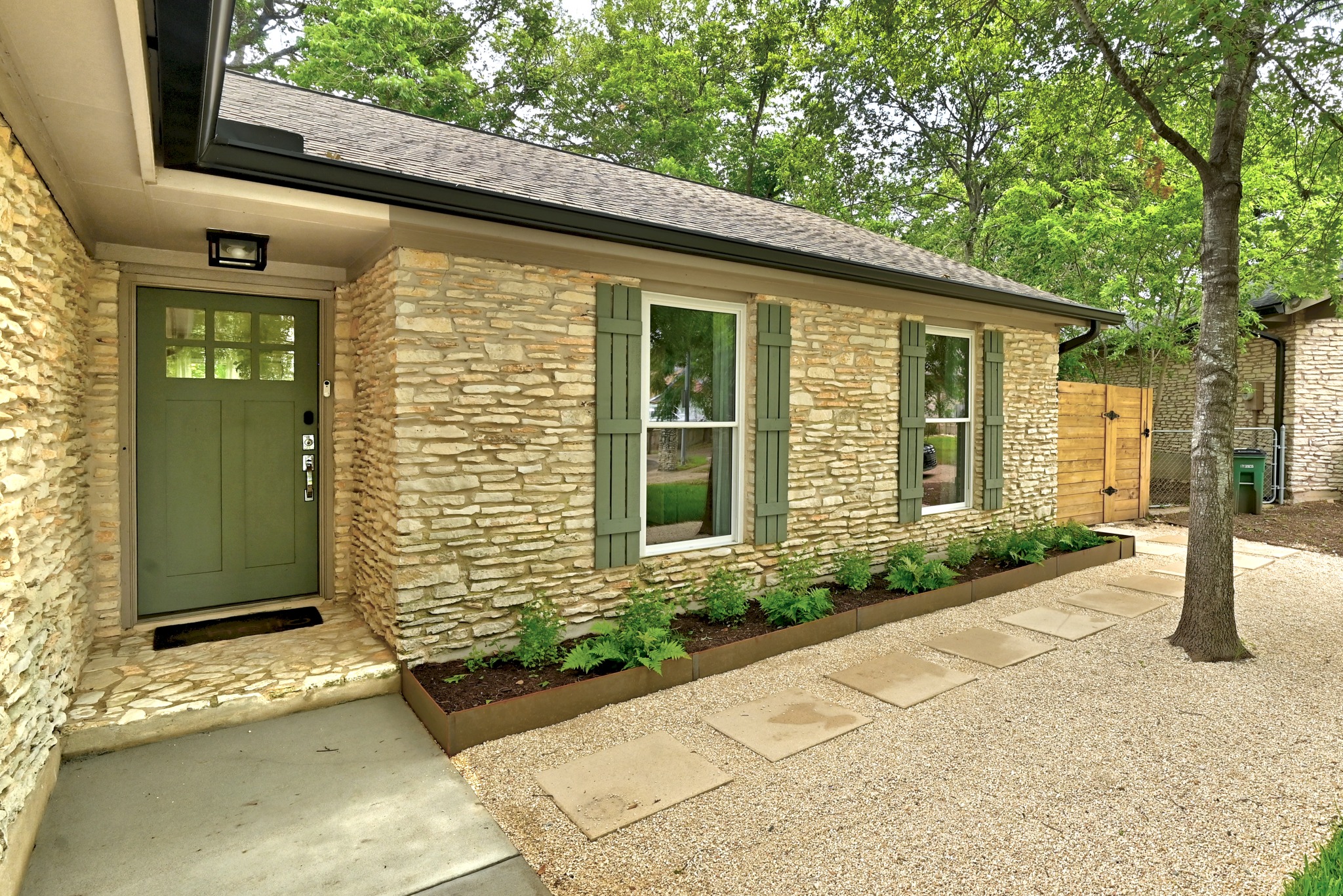 7110 Windrift Way Austin, TX 78745 - Photo 4 of 30 Crafted with natural stone, this residence welcomes with a vibrant entry and tasteful shutters.