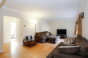 7231 North Ridge Boulevard, Unit 1E Chicago, IL 60645 - Photo 3 of 9 a living room with furniture and a flat screen tv