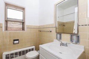 7231 North Ridge Boulevard, Unit 1E Chicago, IL 60645 - Photo 8 of 9 a bathroom with a sink toilet and mirror