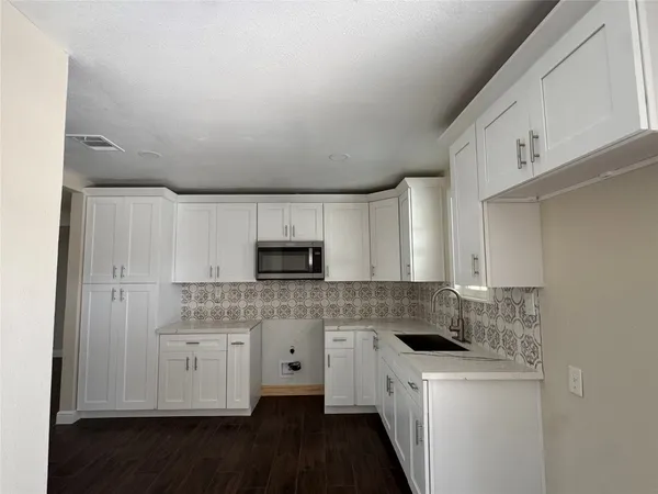 a kitchen with a sink a stove a microwave and cabinets