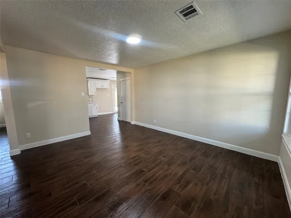 a view of an empty room with wooden floor