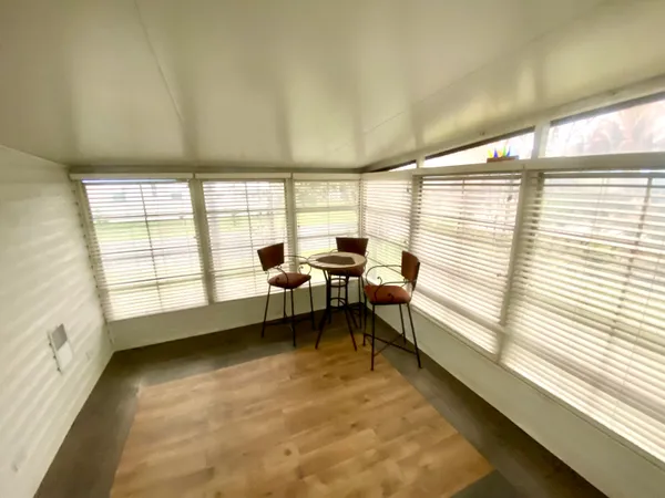 a view of a room with lounge chair windows and wooden floor