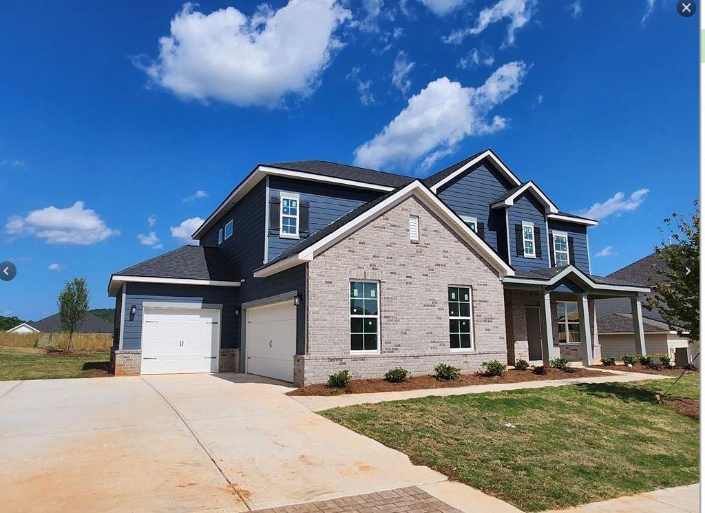a front view of a house with a garden and yard